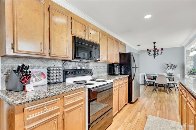 kitchen featuring electric range oven, backsplash, stainless steel fridge, and an inviting chandelier