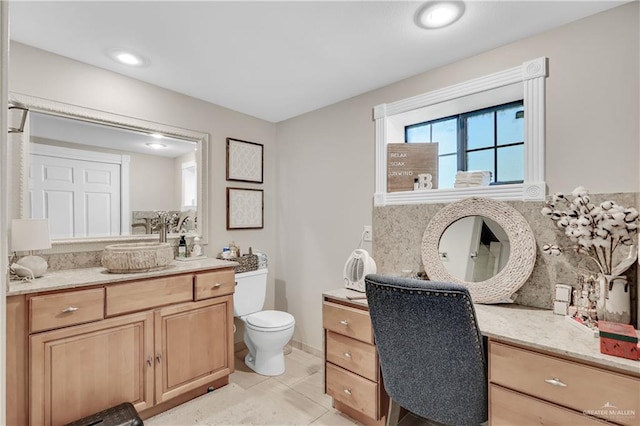 bathroom with toilet, tile patterned flooring, tasteful backsplash, and vanity