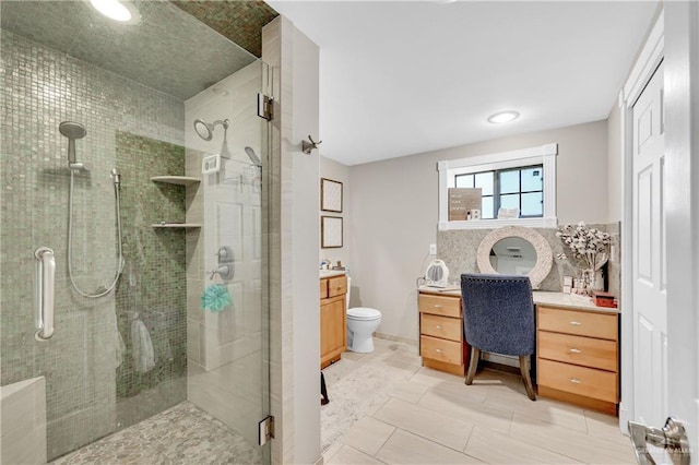 bathroom featuring toilet, tile patterned flooring, a shower with shower door, and vanity