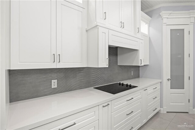 3313 Showboat Dr, Edinburg, TX 78541 - kitchen featuring black electric stovetop, white cabinets, light countertops, tasteful backsplash, and ornamental molding