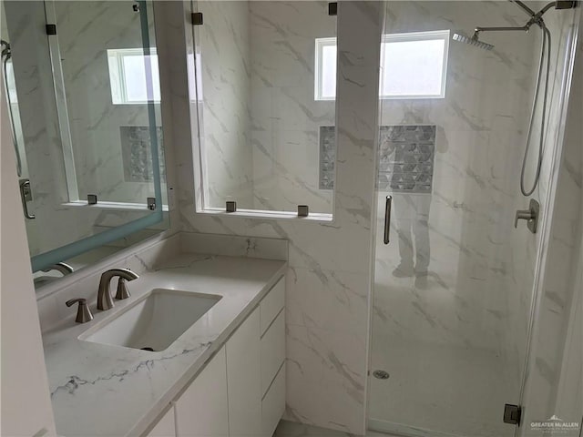 bathroom featuring a shower with door and vanity