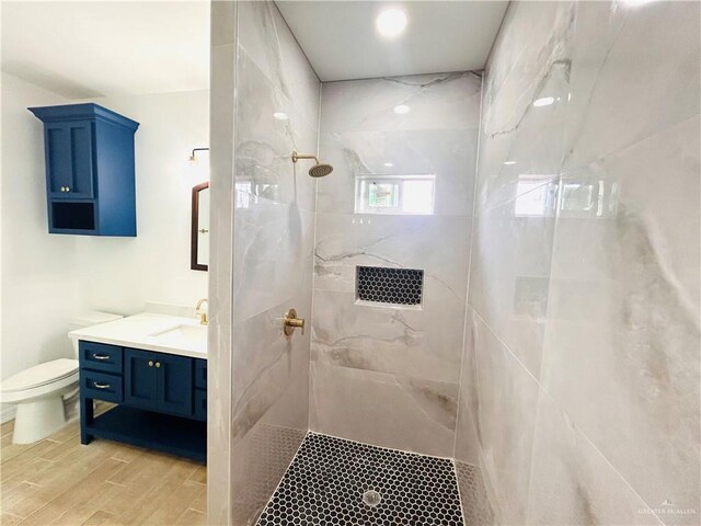412 S Bowie Ave, Elsa, TX 78538 - full bath with a tile shower, vanity, toilet, and wood finished floors