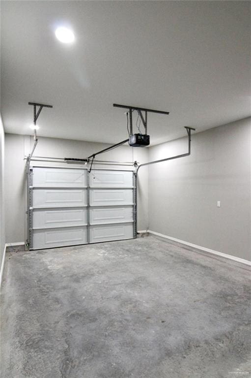 garage featuring a garage door opener and baseboards