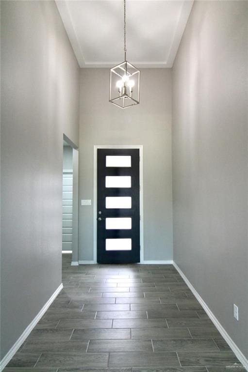 entrance foyer featuring a chandelier, wood finish floors, and baseboards