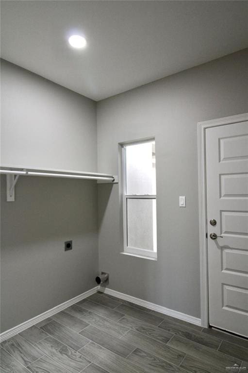 laundry area featuring wood tiled floor, laundry area, hookup for an electric dryer, and baseboards