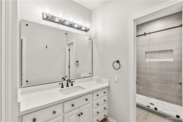 bathroom featuring a shower with door and vanity