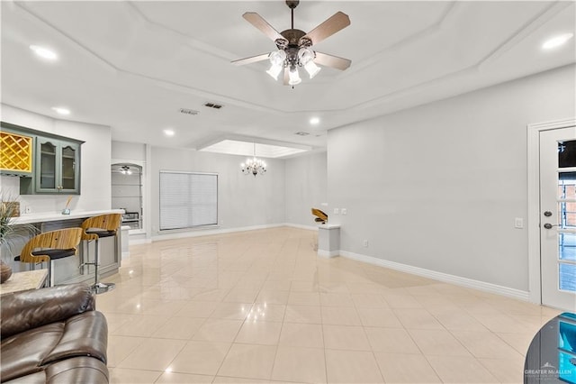 living room featuring tile patterned floors and ceiling fan with notable chandelier