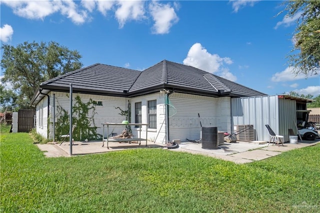 back of property featuring a yard and a patio area