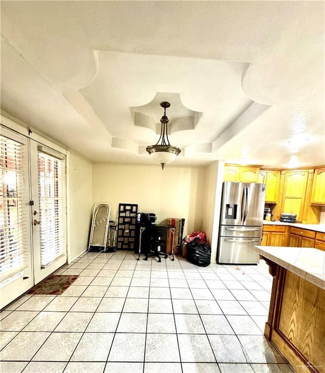 2724 La Villita St, Brownsville, TX 78521 - kitchen with stainless steel fridge, a tray ceiling, light countertops, and light tile patterned flooring
