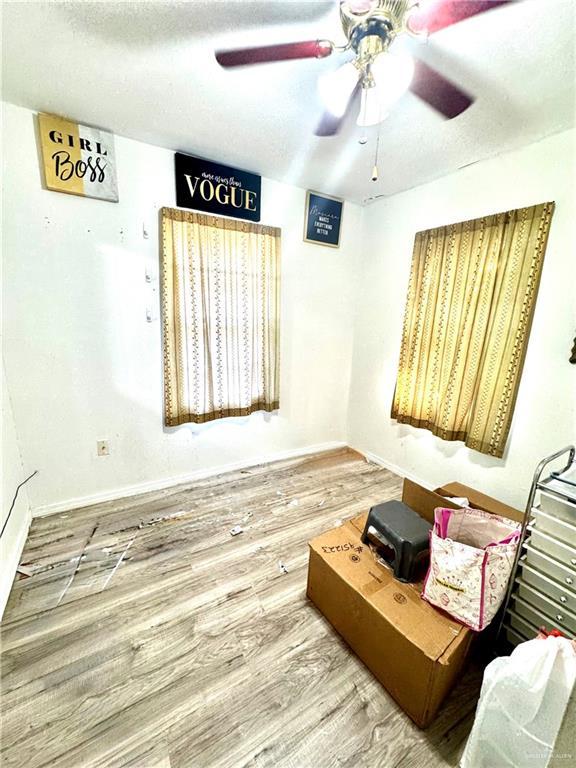 2724 La Villita St, Brownsville, TX 78521 - unfurnished room with wood finished floors, ceiling fan, baseboards, and a textured ceiling