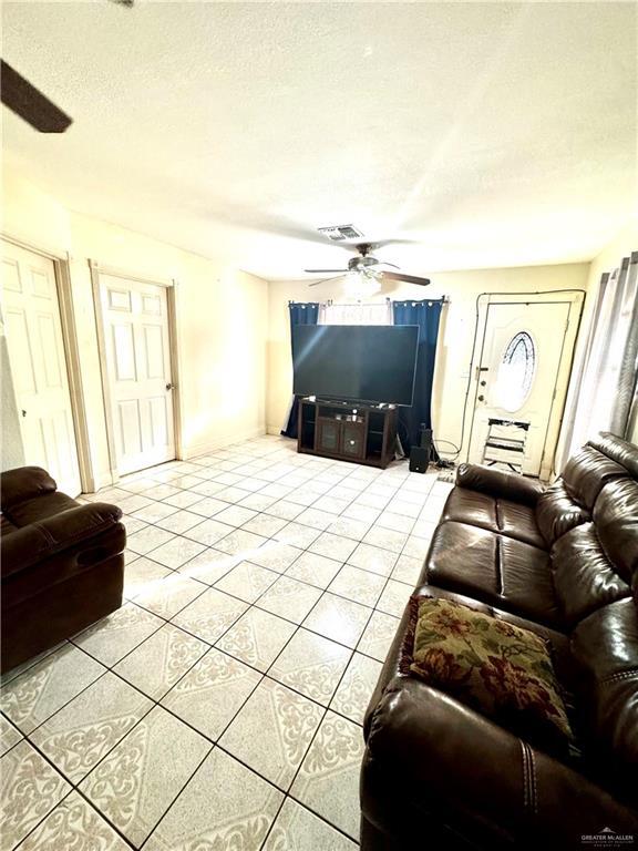 2724 La Villita St, Brownsville, TX 78521 - living room featuring ceiling fan, light tile patterned floors, a textured ceiling, and plenty of natural light