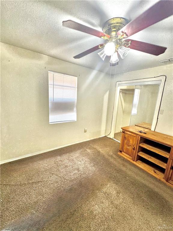 2724 La Villita St, Brownsville, TX 78521 - unfurnished bedroom featuring carpet floors, a textured ceiling, a closet, and ceiling fan