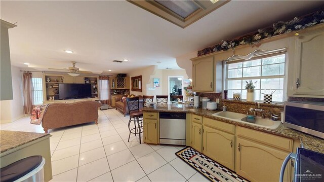 2802 Huisache Ave, Edinburg, TX 78539 - kitchen with stainless steel appliances, a peninsula, a ceiling fan, a sink, and light tile patterned floors