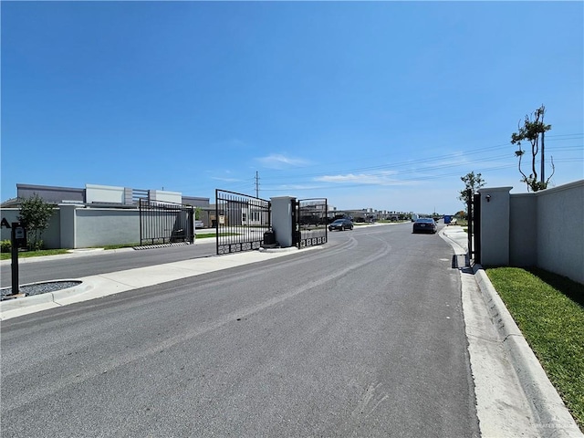 4905 N Hiawatha Dr, Pharr, TX 78577 - view of asphalt road with curbs, a gate, and sidewalks