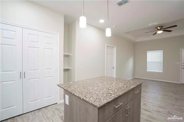 4905 N Hiawatha Dr, Pharr, TX 78577 - kitchen featuring a ceiling fan, light wood-style floors, baseboards, a center island, and a tray ceiling