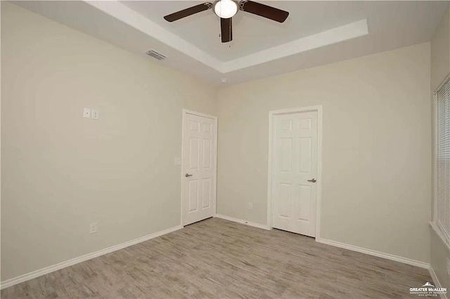 4905 N Hiawatha Dr, Pharr, TX 78577 - unfurnished bedroom with wood finished floors, a tray ceiling, baseboards, and a ceiling fan