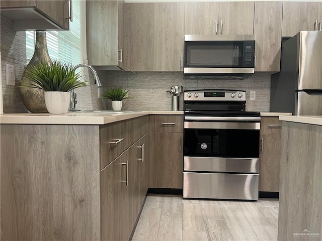 4905 N Hiawatha Dr, Pharr, TX 78577 - kitchen featuring stainless steel appliances, light countertops, decorative backsplash, and modern cabinets