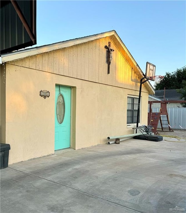 view of side of home featuring basketball hoop