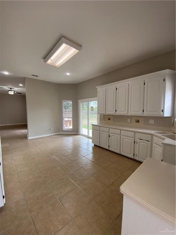 kitchen with white cabinetry, sink, and light tile patterned floors