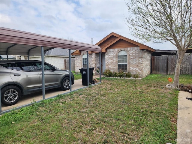 ranch-style house featuring a front yard, fence, a carport, and brick siding