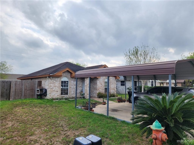 exterior space with brick siding, a lawn, and fence