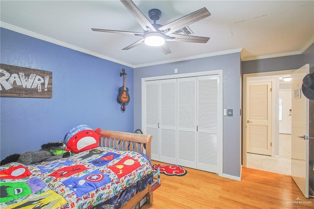 bedroom with hardwood / wood-style floors, a closet, ceiling fan, and ornamental molding