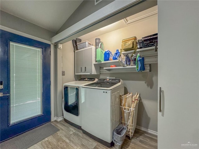 laundry area with cabinets, washer and dryer, and light hardwood / wood-style floors