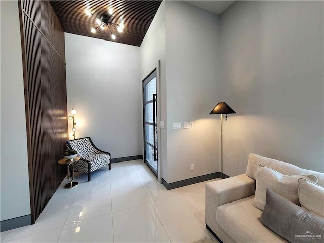 sitting room featuring light tile patterned flooring, wood ceiling, and a high ceiling