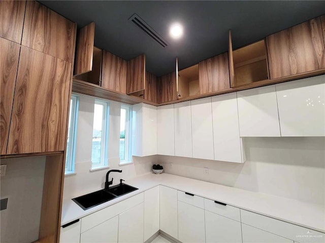 kitchen featuring white cabinetry and sink