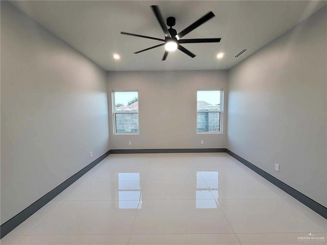 tiled empty room featuring ceiling fan