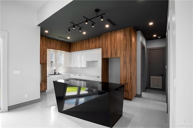 kitchen with white cabinetry, sink, and light tile patterned floors