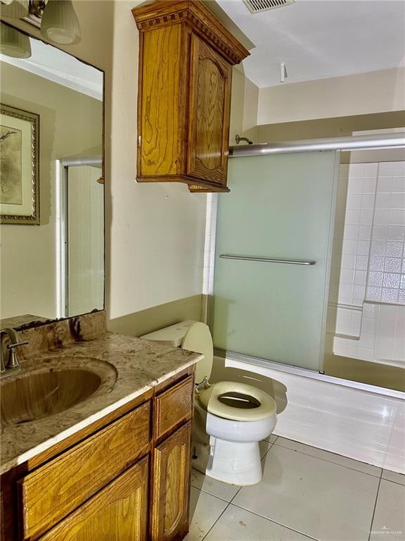 full bathroom featuring toilet, vanity, tile patterned floors, and shower / bath combination with glass door