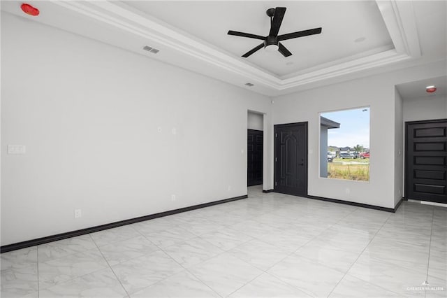 unfurnished room featuring a tray ceiling, ceiling fan, and ornamental molding