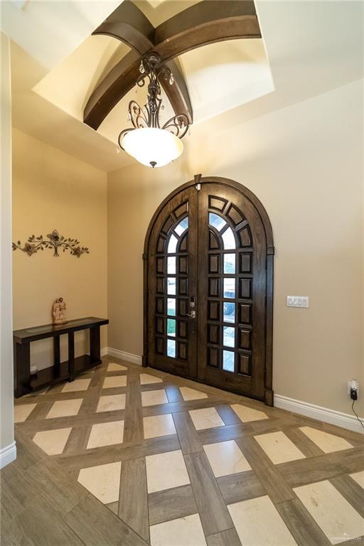 816 Samaria St, Weslaco, TX 78596 - entryway featuring baseboards, arched walkways, french doors, and inlaid floor details