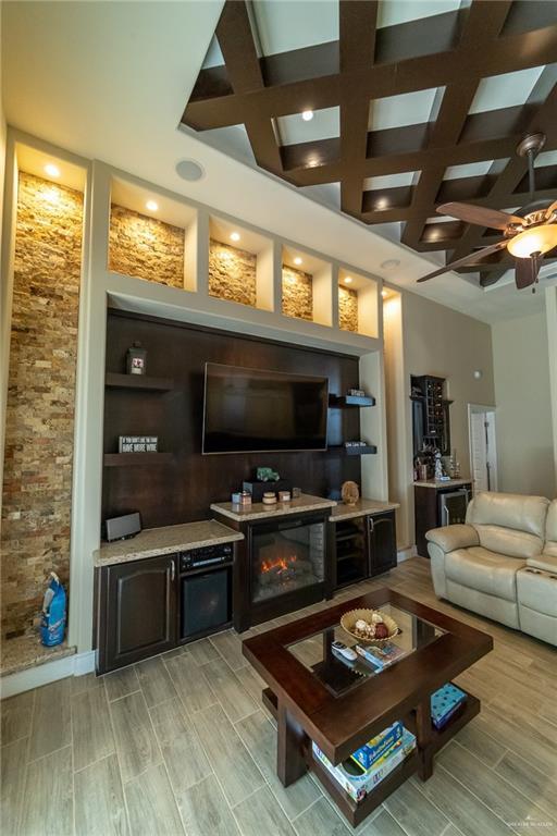 816 Samaria St, Weslaco, TX 78596 - living area with coffered ceiling, wood tiled floors, beamed ceiling, ceiling fan, and recessed lighting