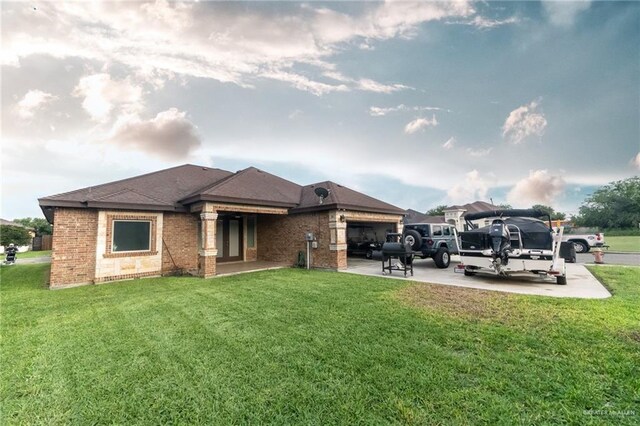 816 Samaria St, Weslaco, TX 78596 - rear view of house featuring a garage, brick siding, and a yard
