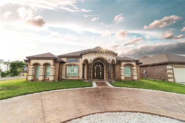 816 Samaria St, Weslaco, TX 78596 - view of front of house with brick siding, a front yard, and french doors