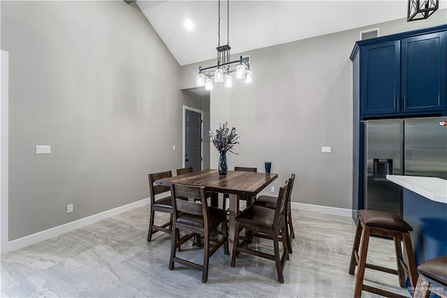 dining space with high vaulted ceiling and a notable chandelier