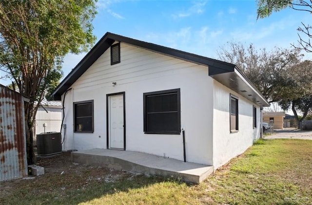 back of house with a yard and central air condition unit