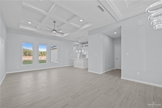 unfurnished living room featuring beam ceiling, ceiling fan with notable chandelier, and coffered ceiling