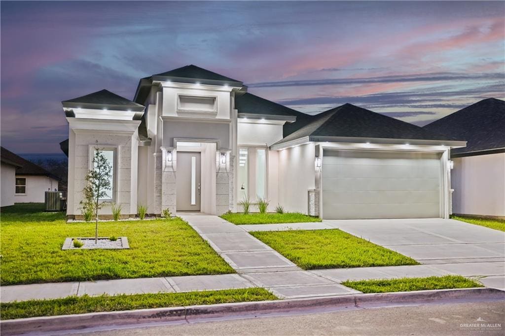 view of front of property featuring a lawn, cooling unit, and a garage