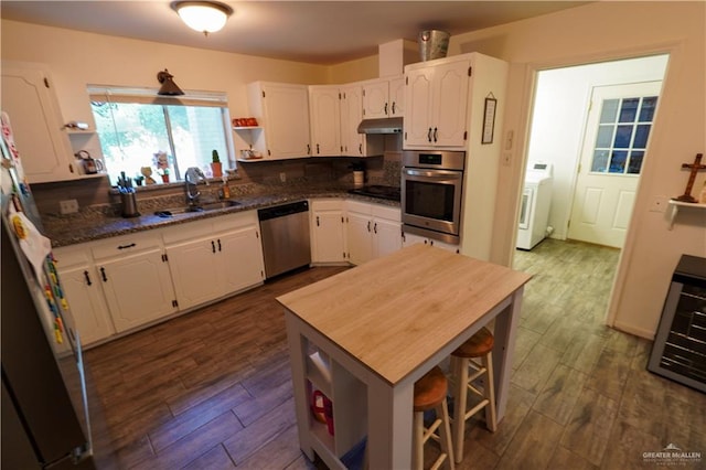 kitchen featuring stainless steel appliances, white cabinetry, dark hardwood / wood-style floors, and sink