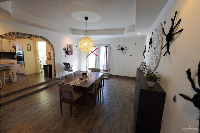 dining room with french doors, a raised ceiling, and dark wood-type flooring