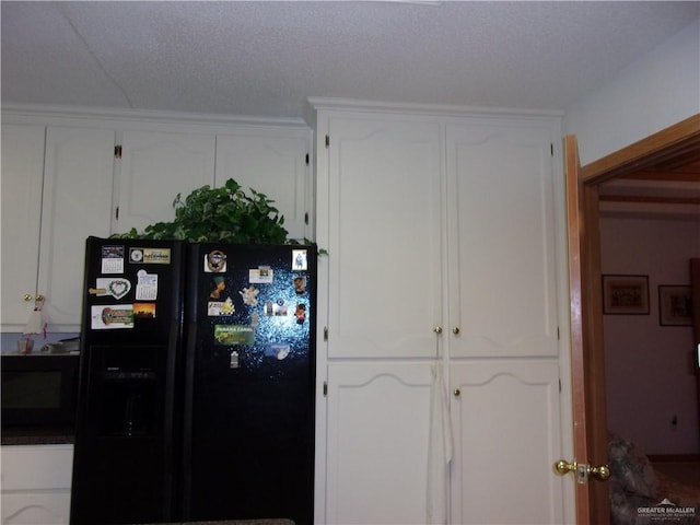 kitchen featuring white cabinetry and black refrigerator with ice dispenser