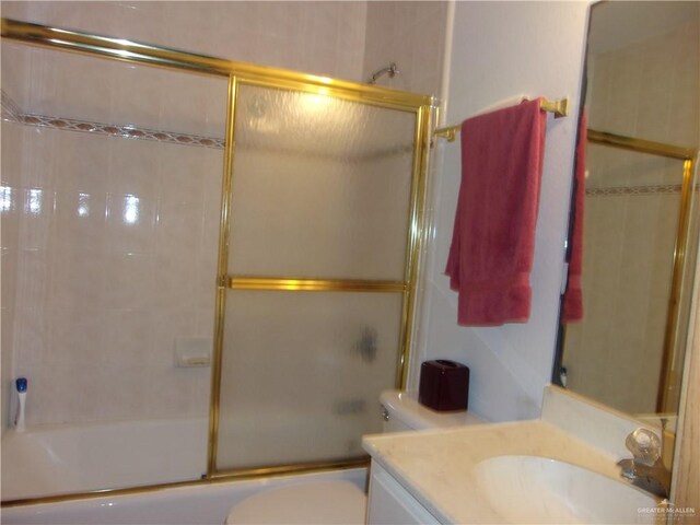 full bathroom with vanity, enclosed tub / shower combo, and toilet