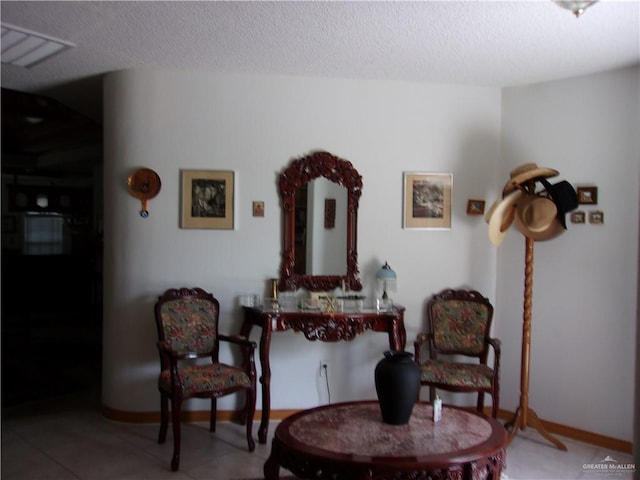 sitting room with tile patterned flooring and a textured ceiling