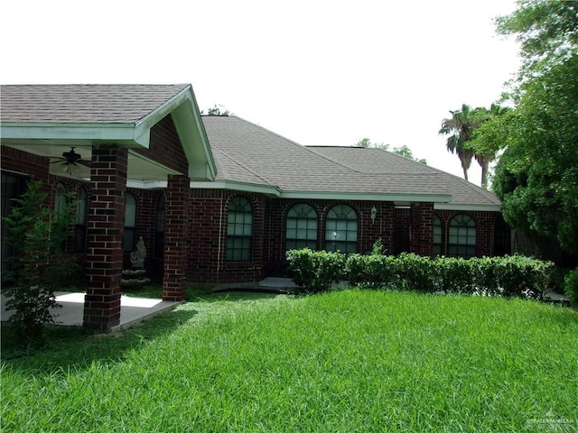 exterior space with ceiling fan and a lawn