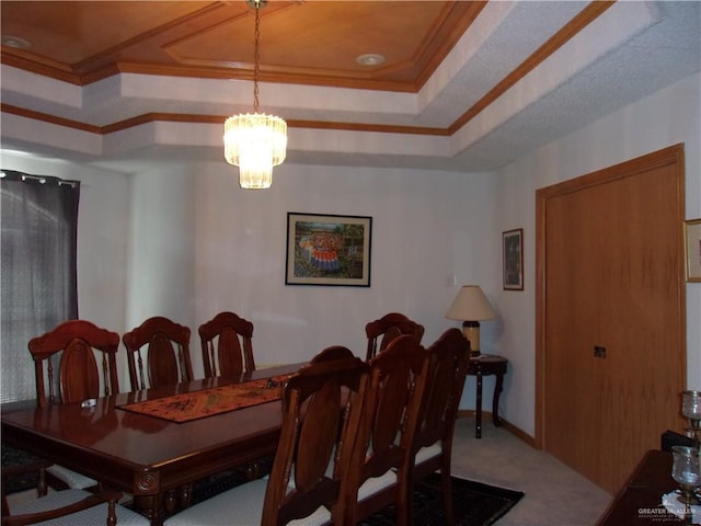 dining area featuring carpet flooring, a raised ceiling, crown molding, and a chandelier