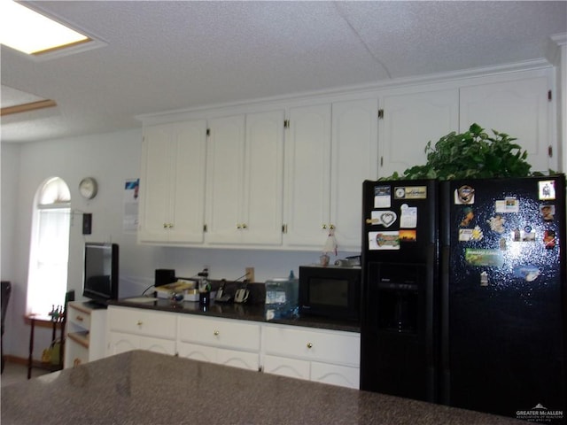 kitchen featuring white cabinets and black appliances