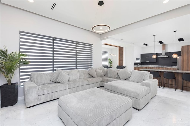 living area featuring recessed lighting, marble finish floor, and visible vents